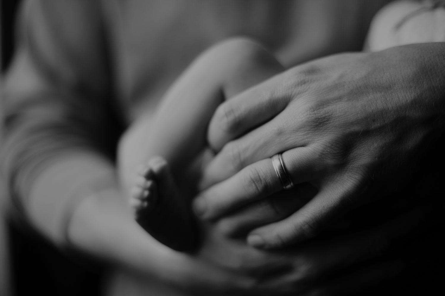 A black & white photo of a father holding his infant child
