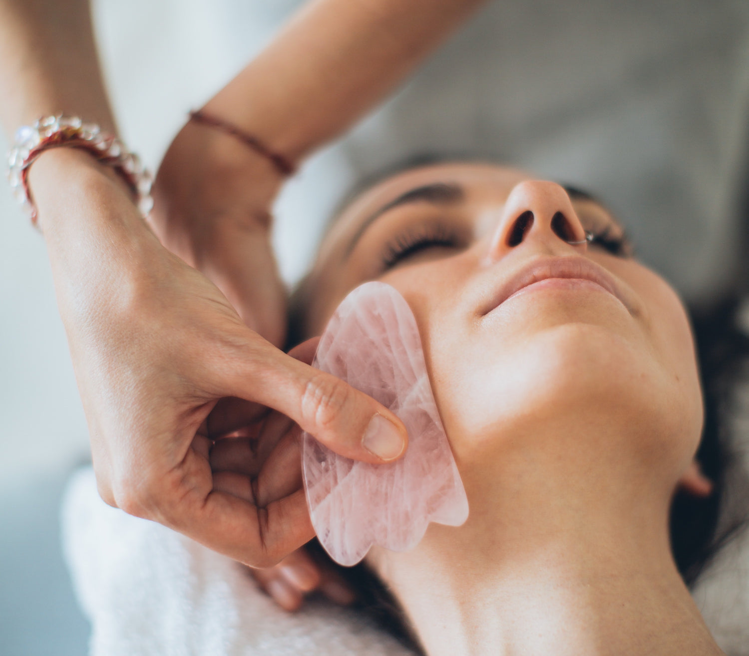 Woman having a gua sha performed on her face