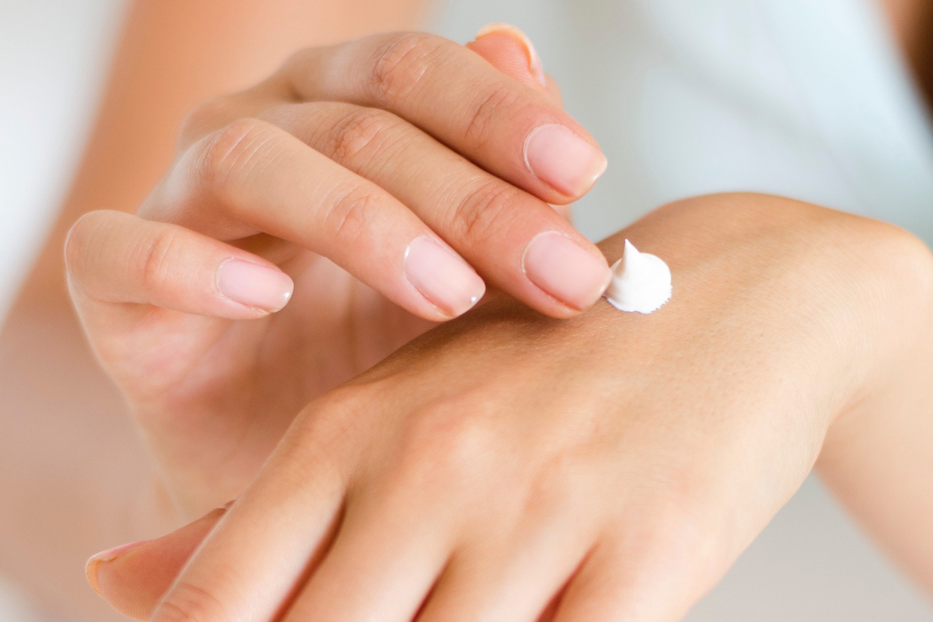 Woman applying ceramide cream to skin